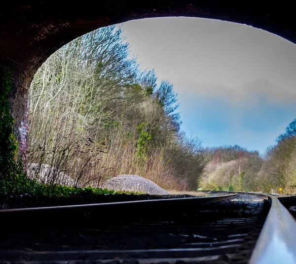 Birmingham, Wielka Brytania - marca 2018 kąt widzenia suche gałązki i gałęzie poza tunel. Torów na pierwszym planie krawężnika na samym końcu. Pod ziemią ściany murowane są brudne i Weathered. — Zdjęcie stockowe