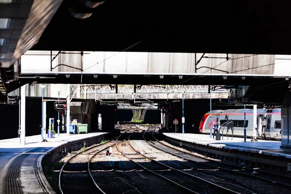 Birmingham, uk - März 2018 Zug geparkt auf Eindämmung Bahnhof unter einer Struktur. Eisenbahngleise verflechten sich in chaotischer Begegnung am anderen Ende. eine Person auf dem Bahnsteig. — Stockfoto