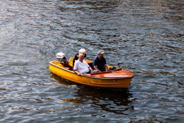 Birmingham, İngiltere - gemide Mart 2018 insanlarda küçük açık Motorbot adil gün. Turuncu gemi ile dalgalı denizde yelken dıştan takma motor. Üç yetişkin nehir zevk Tur Cruise.