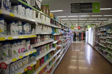 Birmingham, İngiltere - Mart 2018 Asda müşteriler kişisel bakım ürünleri için alışveriş. Kırmızı Etiketler seçilen öğeler üzerinde indirim. Tuvalet süpermarkette koridor bölümüne. Temiz ve parlak kahverengi zemin.