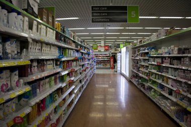 Birmingham, İngiltere - Mart 2018 Asda koridor tuvalet süpermarkette. Kırmızı satış seçilmiş kalemler Etiketler. Parlak zemin ışık yansıtan. Tavanda asılı kişisel bakım bölümü tabela.