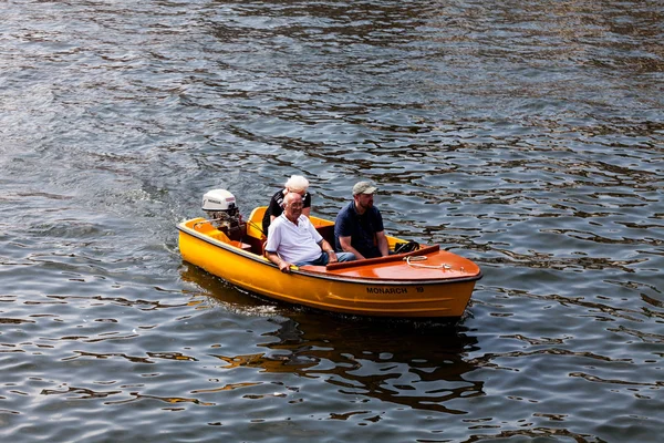 Birmingham, İngiltere - gemide Mart 2018 insanlarda küçük açık Motorbot adil gün. Turuncu gemi ile dalgalı denizde yelken dıştan takma motor. Üç yetişkin nehir zevk Tur Cruise.