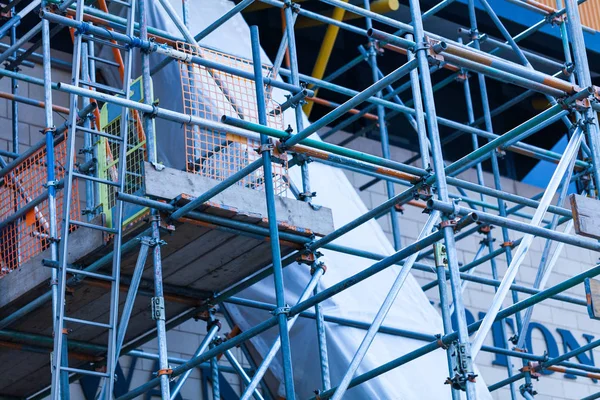 The steel scaffold is set up on a renovated building. Construction site with steel scaffolds. — Stock Photo, Image