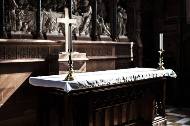 Hıristiyan çapraz kilisenin sunak üzerinde. Mumlar kilisenin sunak önünde masada. Hıristiyan kilisenin sunak olarak koyu arka plan.