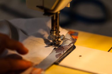 Kadın dikiş makinesi üzerinde eller. Kıyafetler oluşturma ile sanayi kavramı. 