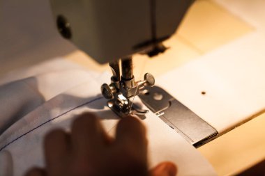Kadın dikiş makinesi üzerinde eller. Kıyafetler oluşturma ile sanayi kavramı. 
