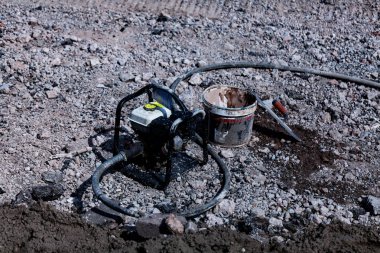 Su pompası inşaat sitesinde kullanma. Yere endüstriyel araçlarıyla plastik kova.