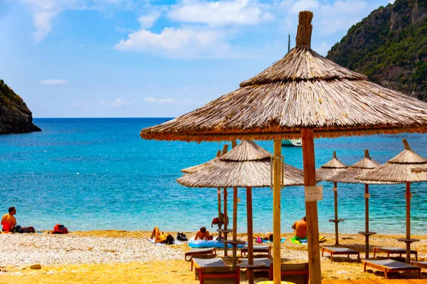 Dia ensolarado na praia com guarda-chuvas e assentos. Céu azul no belo tempo. Imagem de conceito de férias com mar e céu . — Fotografia de Stock