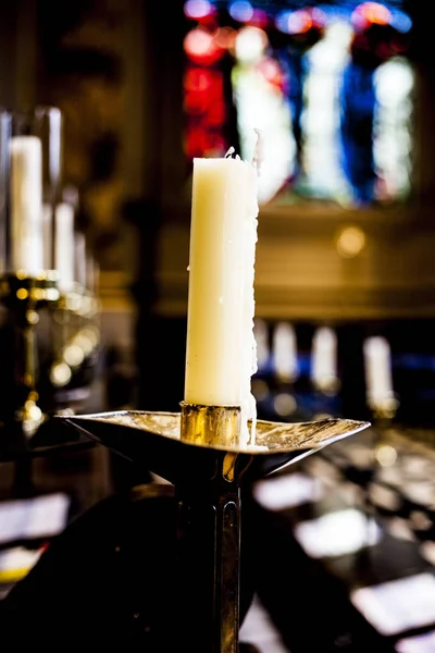 Las llamas de las velas en la iglesia cristiana. Grupo de velas amarillas en la iglesia. Humor oscuro con velas quemadas . —  Fotos de Stock