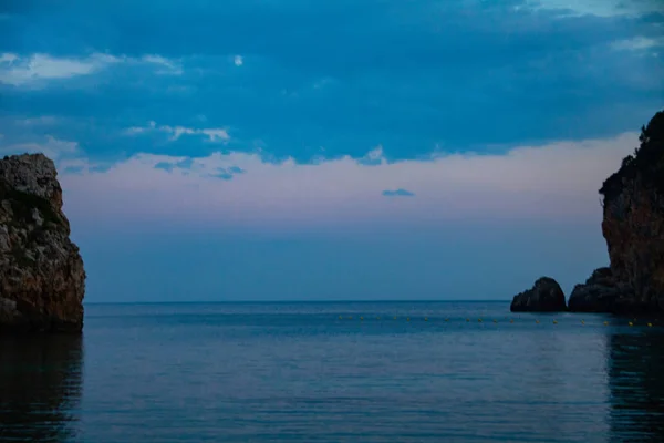 Uma praia de areia no mar no crepúsculo com um céu azul no fundo. Conceito de calma e paz no feriado . — Fotografia de Stock