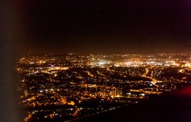 Şehir ışıklarını uçak ile koyu arka plan bakış. Gece şehir ışıkları. Karanlık gece şehir ışıkları yukarıda görünümünü uçak.