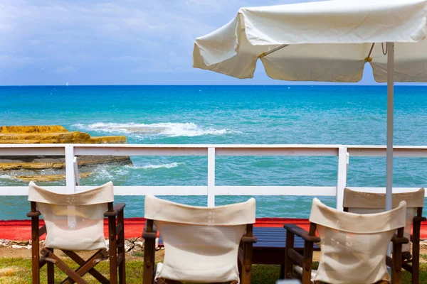 Día soleado en la playa con sombrillas y asientos. Cielo azul ante el hermoso clima. Imagen de concepto de vacaciones con mar y cielo . — Foto de Stock