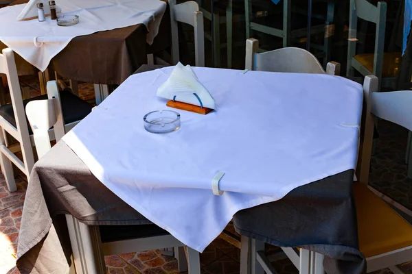 Mesa no restaurante com toalha de mesa branca e guardanapos brancos no suporte . — Fotografia de Stock