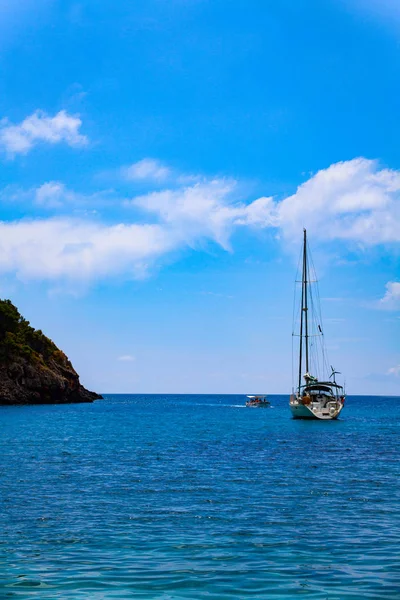 Voilier sur la mer par une belle journée ensoleillée. Belle journée ensoleillée avec des nuages sur la mer avec un bateau . — Photo