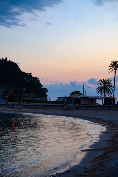 Una spiaggia di sabbia al mare nel crepuscolo con un cielo blu sullo sfondo. Concetto di calma e pace durante le vacanze . — Foto Stock