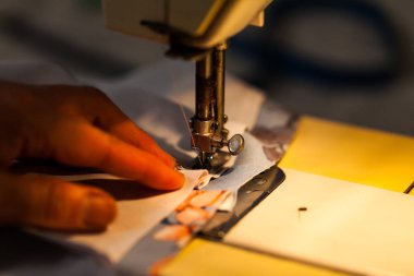 Kadın dikiş makinesi üzerinde eller. Kıyafetler oluşturma ile sanayi kavramı. 