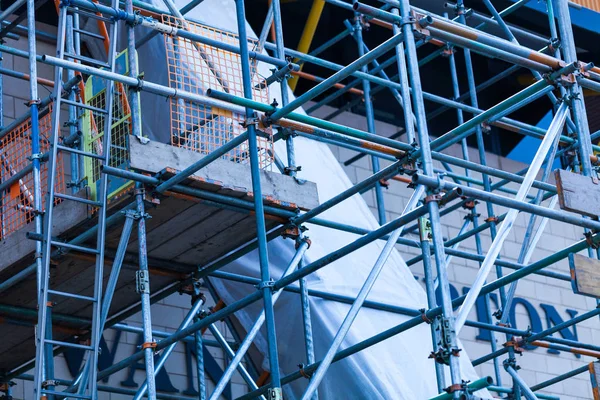 The steel scaffold is set up on a renovated building. Construction site with steel scaffolds. — Stock Photo, Image