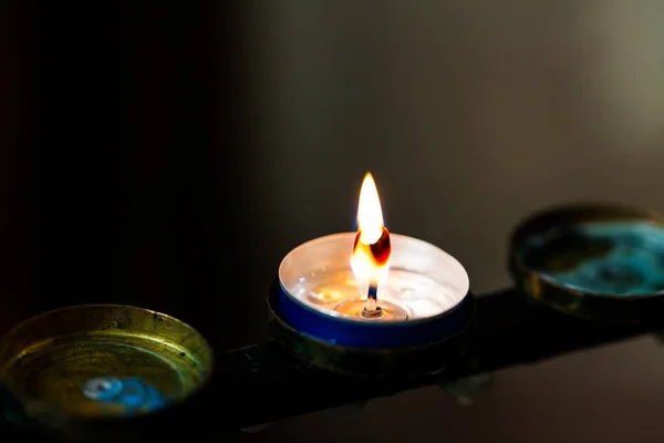 Pequena vela acesa no escuro. Copiar espaço com chama da vela . — Fotografia de Stock