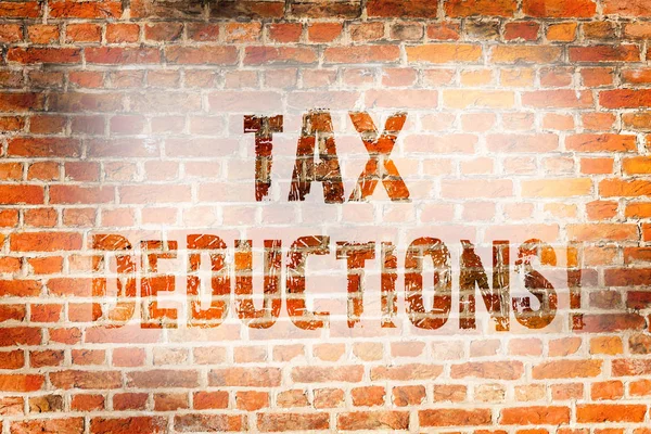 Conceptual hand writing showing Tax Deductions. Business photo showcasing Reduction on taxes Investment Savings Money Returns Brick Wall art like Graffiti motivational written on wall. — Stock Photo, Image