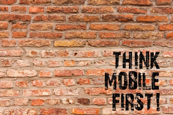 Написание почерка Think Mobile First. Концепция означает Портативные устройства маркетинга целевых портативных телефонов в первую очередь Кирпичные стены искусства, как граффити мотивационный вызов написан на стене . — стоковое фото