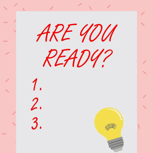 Text sign showing Are You Ready Question. Conceptual photo used telling someone start something when feel prepared Incandescent Light Bulb with Filament Inside Resting on Blank Color Paper.