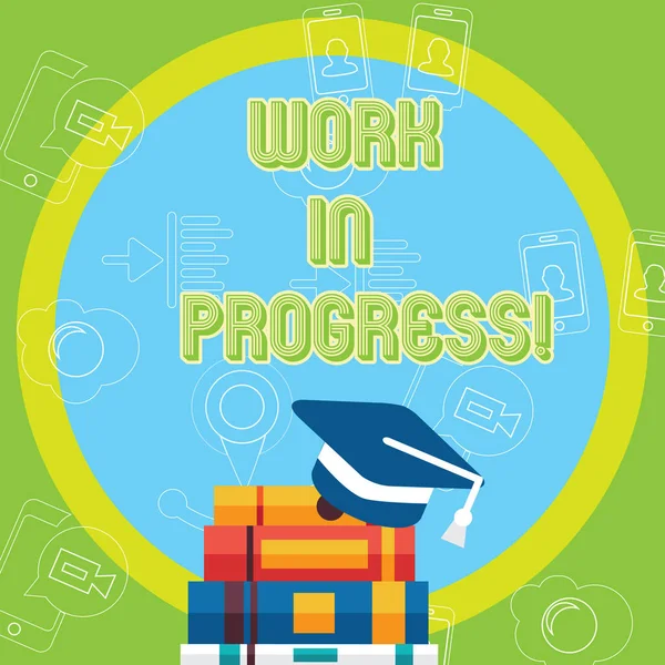 Text sign showing Work In Progress. Conceptual photo People is working right know to deliver expected results Graduation Cap with Tassel Resting on Top of Stack of Colorful Thick Books.