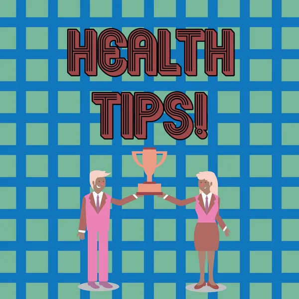 Text sign showing Health Tips. Conceptual photo state of complete physical mental and social well being advices Man and Woman in Business Suit Holding Together the Championship Trophy Cup. — Stock Photo, Image