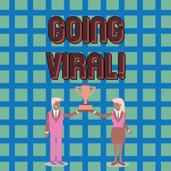 ป้ายข้อความแสดงว่า Going Viral วิดีโอภาพถ่ายแนวคิดหรือภาพแพร่กระจายอย่างรวดเร็วและกว้างขวางในหมู่ผู้ใช้อินเทอร์เน็ต ชายและหญิงในชุดธุรกิจถือร่วมกันถ้วยรางวัลชิงแชมป์ . — ภาพถ่ายสต็อก