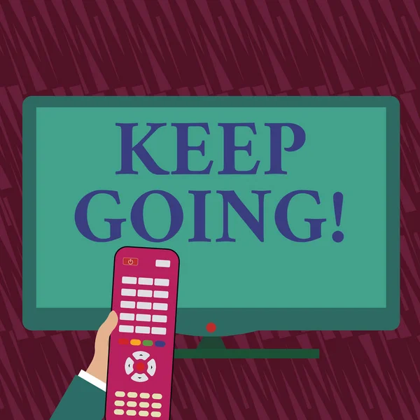 Text sign showing Keep Going. Conceptual photo make effort to live normally in spite of difficulty situation Hand Holding Computer Remote Control infront of Blank Wide Color PC Screen.