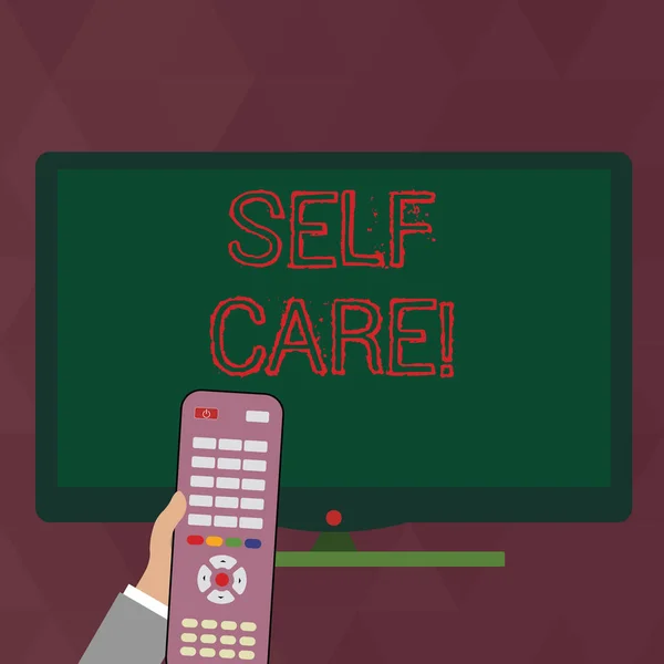 Writing note showing Self Care. Business photo showcasing practice of taking action preserve or improve ones own health Hand Holding Remote Control infront of Wide Color PC Screen.
