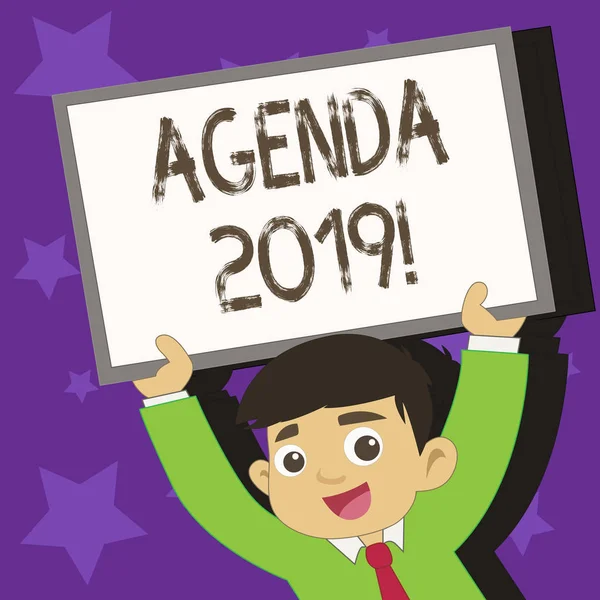 Conceptual hand writing showing Agenda 2019. Business photo text list of items to be discussed at formal meeting or event Young Student Raising Upward Frame Whiteboard Above his Head.