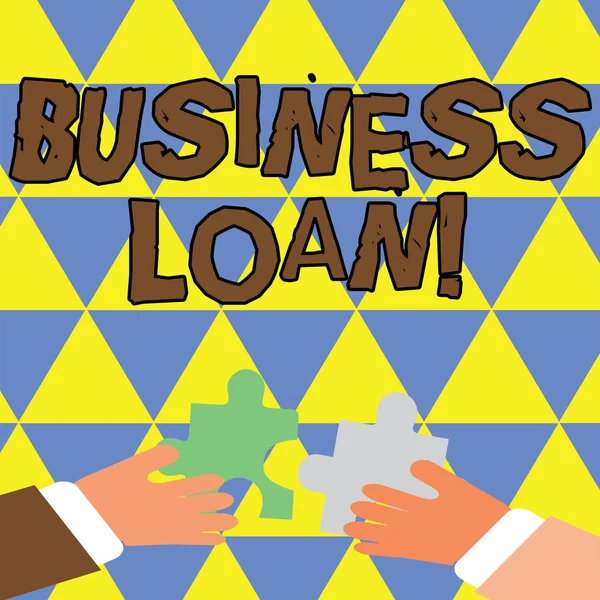 Writing note showing Business Loan. Business photo showcasing creation of debt which will be repaid with added interest Hands Holding Jigsaw Puzzle Pieces about Interlock the Tiles.