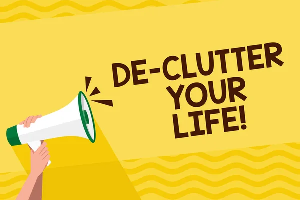 Palavra de texto De Clutter Your Life. Conceito de negócio para remover bagunça de lugar organizar e priorizar a mão humana segurando firmemente um megafone com ícone de som e espaço em branco . — Fotografia de Stock