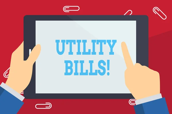 Writing note showing Utility Bills. Business photo showcasing amount household expected pay for electricity water each month Businessman Hand Holding and Pointing Colorful Tablet Screen.