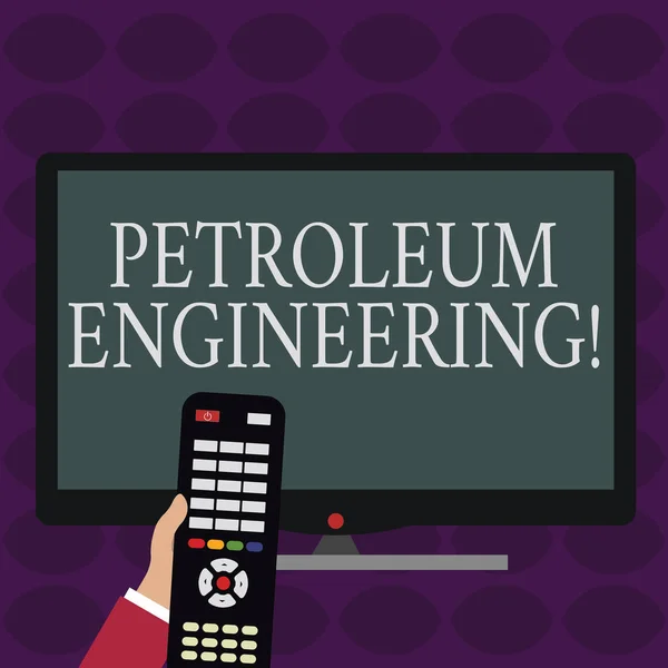 Escritura a mano de texto Petroleum Engineering. Concepto que significa Actividades relacionadas con la producción de hidrocarburos Mano que sostiene la computadora Control remoto frente a la pantalla de PC en color ancho en blanco . — Foto de Stock