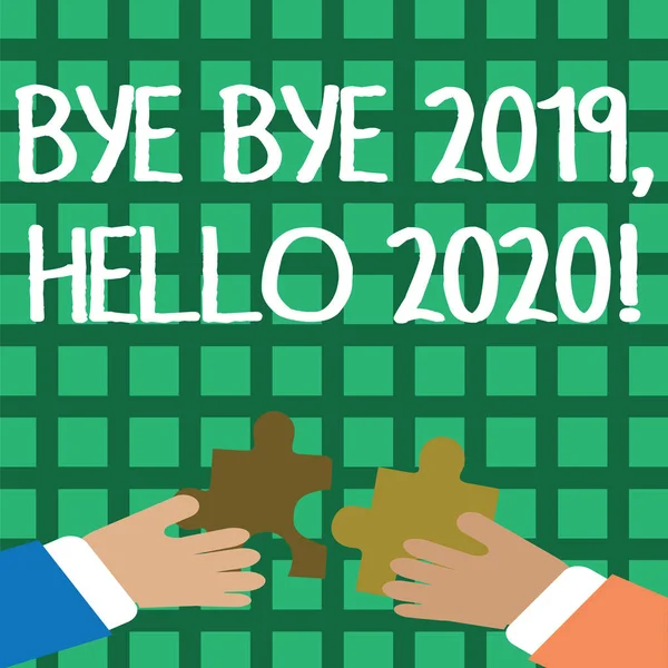 Conceptual hand writing showing Bye Bye 2019 Hello 2020. Business photo showcasing saying goodbye to last year and welcoming another good one Hands Holding Jigsaw Puzzle Pieces about Interlock the