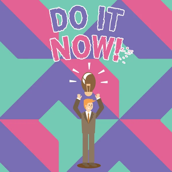 Writing note showing Do It Now. Business photo showcasing not hesitate and start working or doing stuff right away Businessman Raising Arms Upward with Lighted Bulb icon above.