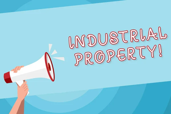 Text sign showing Industrial Property. Conceptual photo the intangible ownership of a trademark or patent Human Hand Holding Tightly a Megaphone with Sound Icon and Blank Text Space.