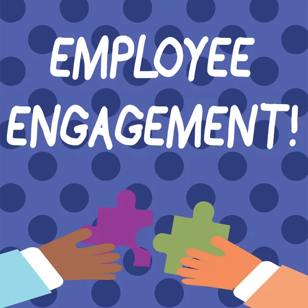 Handwriting text writing Employee Engagement. Concept meaning relationship between an organization and its employees Two Hands Holding Colorful Jigsaw Puzzle Pieces about to Interlock the Tiles.