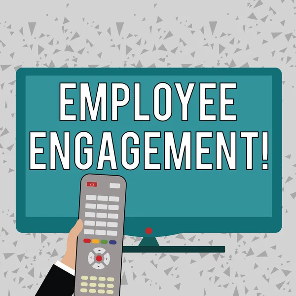 Word writing text Employee Engagement. Business concept for relationship between an organization and its employees Hand Holding Computer Remote Control infront of Blank Wide Color PC Screen.