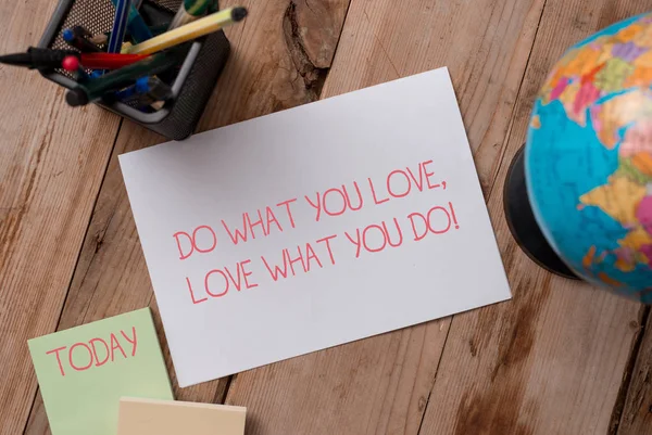 Writing note showing Do What You Love Love What You Do. Business photo showcasing you able doing stuff you enjoy it to work in better places then Writing equipments and sheets with artificial globe on