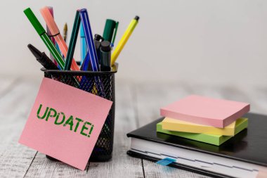 El yazısı metin Güncelleştirme. Kavram anlamı bir şey daha modern ya da yazılım programı yazma ekipmanları ve ahşap masa üzerinde gündem kitabı ile not kağıt sayfaları gibi güncel yapmak.