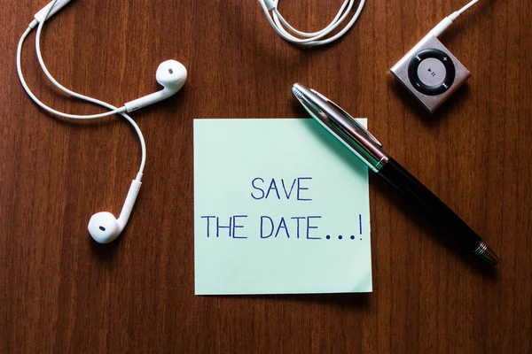 Handwriting text writing Save The Date. Concept meaning Organizing events well make day special event organizers Upper view earphones music device and stick pad lying wooden timber table. — Stock Photo, Image
