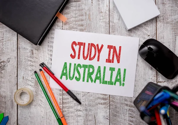 Writing note showing Study In Australia. Business photo showcasing going into foreign country order complete your studies Stationary and computer stuff pen with paper sheets on desk.