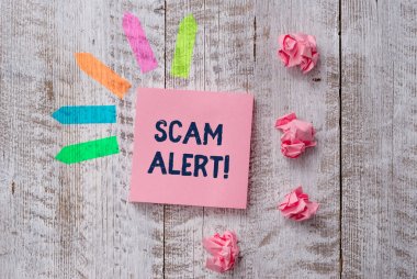 El yazısı metin yazma Scam Alert. Kavram hileli onu ahşap masa nın üstüne Düz not kağıt ve çizgi ok çıkartmaları ikna ederek kurbandan para elde anlamı.