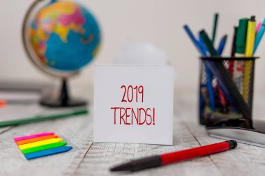 2019 Trendlerini gösteren metin işareti. Bir şeyin kırtasiye ve kağıt tabakaları artı tahta masa üzerinde küre ile küçük oklar geliştirdiği veya değiştirdiği kavramsal fotoğraf genel yönü.