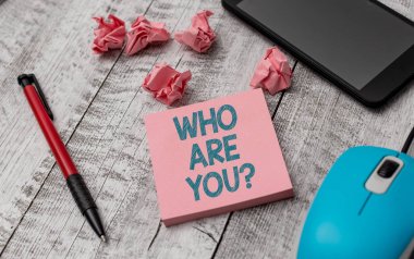 Text sign showing Who Are You Question. Conceptual photo asking about someone identity or demonstratingal information Writing equipment and paper plus scraps with gadgets on the wooden desk.