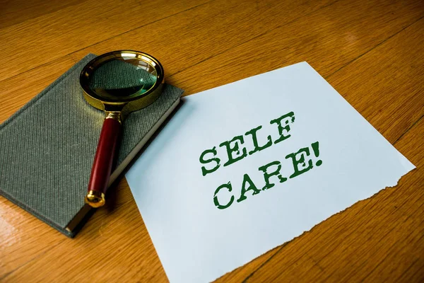 Text sign showing Self Care. Conceptual photo practice of taking action to preserve or improve ones own health Close up electronic device gadget magnifying glass resting wooden table. — Stock Photo, Image