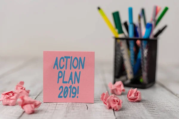 Text sign showing Action Plan 2019. Conceptual photo proposed strategy or course of actions for current year Set of plain note paper with scraps and stationary on the wooden table.