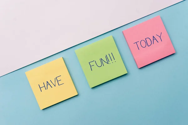 Text sign showing Have Fun. Conceptual photo wish somebody good and enjoyable time when they do something Pastel colour note papers placed sideways on the of softhued backdrop. — Stock Photo, Image